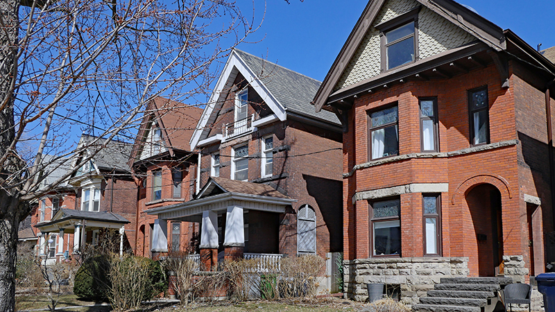 Row of large old Victorian style detached brick houses with gables